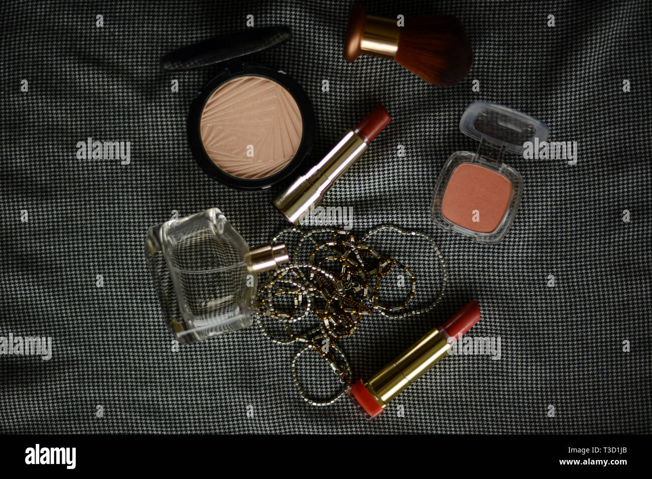 two lipsticks, perfume bottle, necklace, blusher and face powder Stock Photo