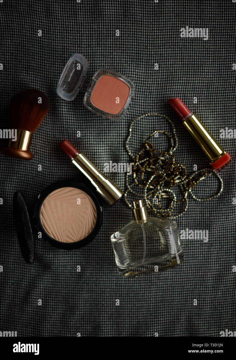 two lipsticks, perfume bottle, necklace, blusher and face powder Stock Photo