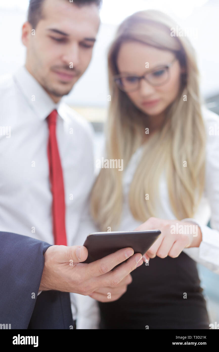 Young businesspeople using tablet in business center, depth of field Stock Photo