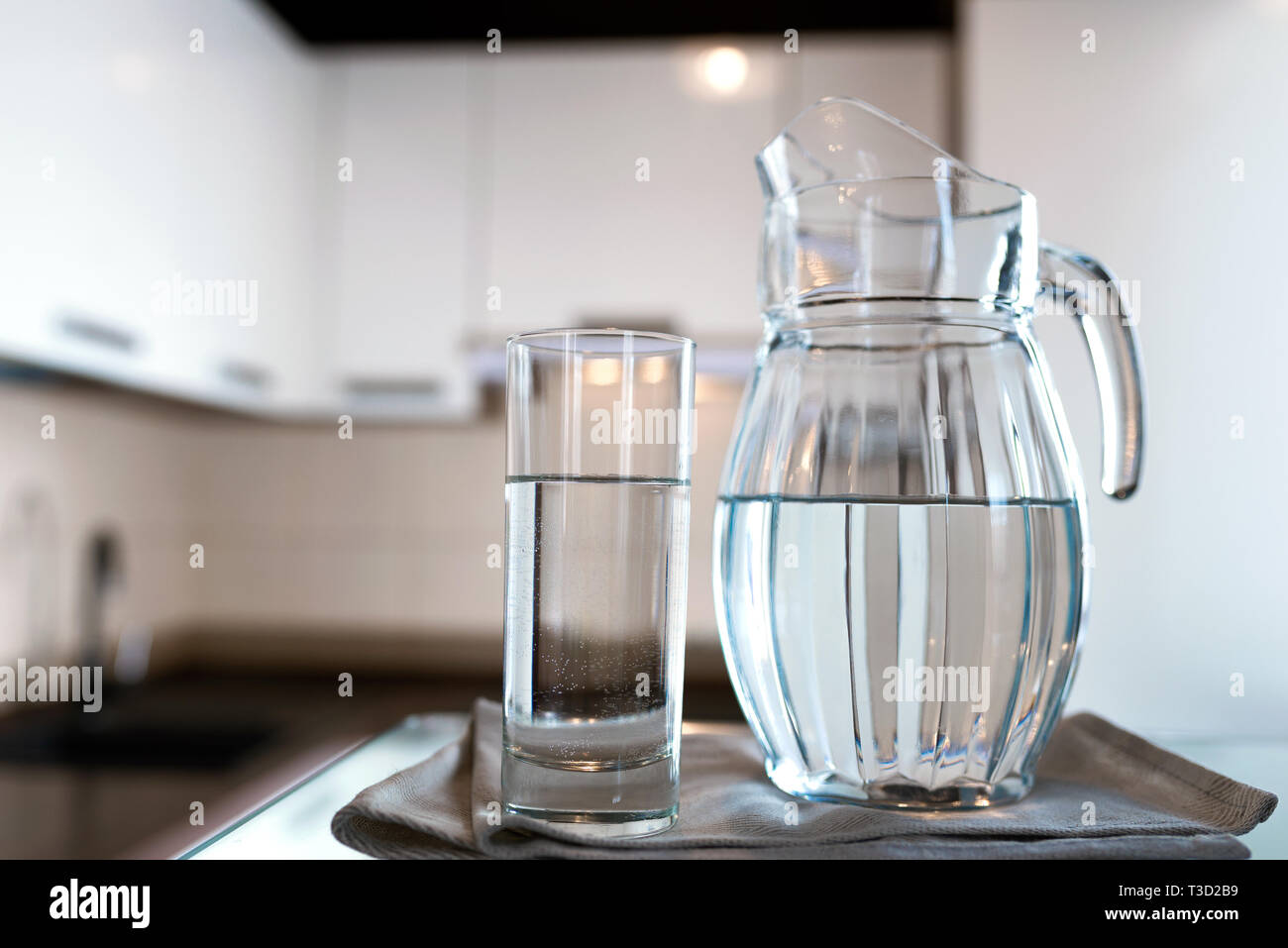 A glass of fresh water with crafin on the background of a modern kitchen. Stock Photo