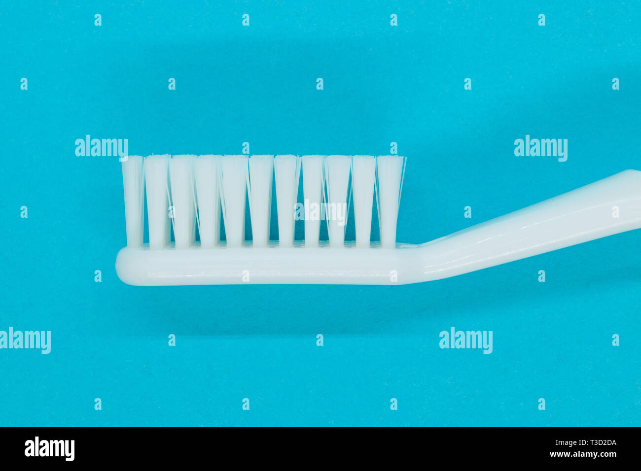 Side view of white toothbrush on blue background Stock Photo - Alamy