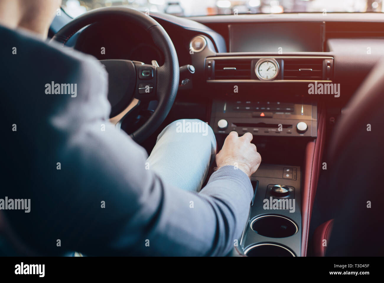 cropped view of man sitting in modern automobile and holding manual transmission Stock Photo