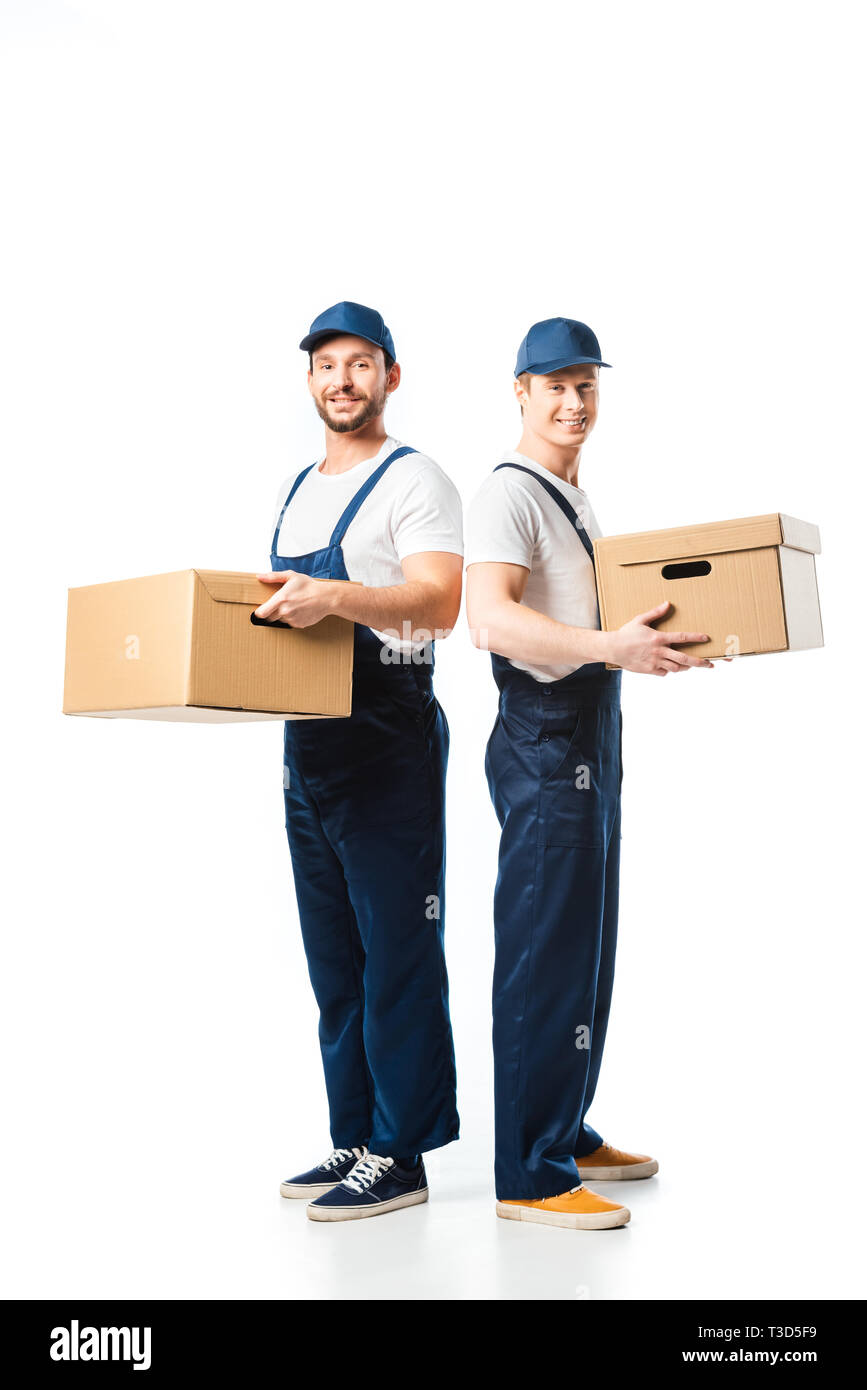 two handsome movers looking at camera while transporting cardboard boxes on white Stock Photo