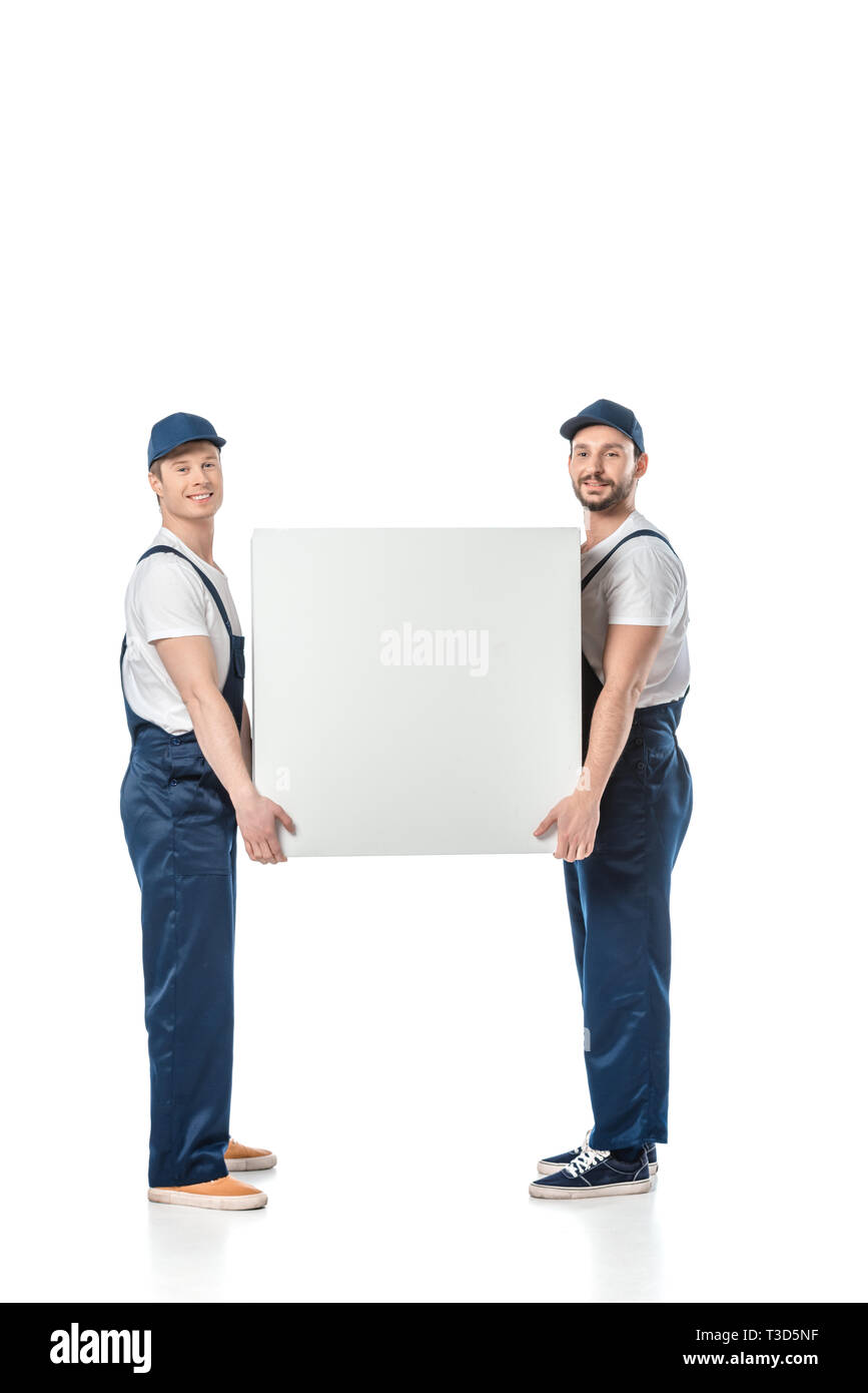 two smiling movers looking at camera while holding blank box isolated on white Stock Photo