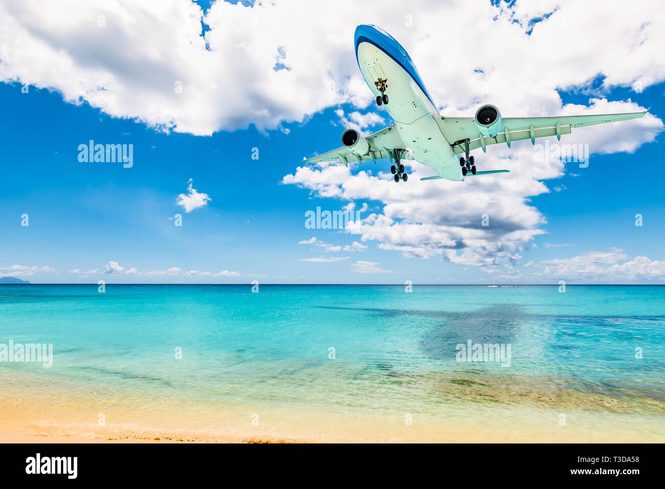 Plane above sea and beach in St Maarten, Caribbean. Travel and air transportation background. Stock Photo