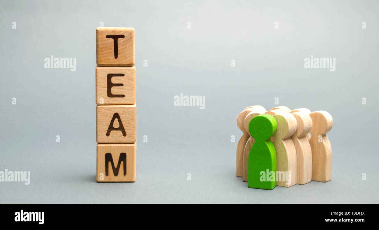 Wooden blocks with the word Team and a crowd of workers with a leader