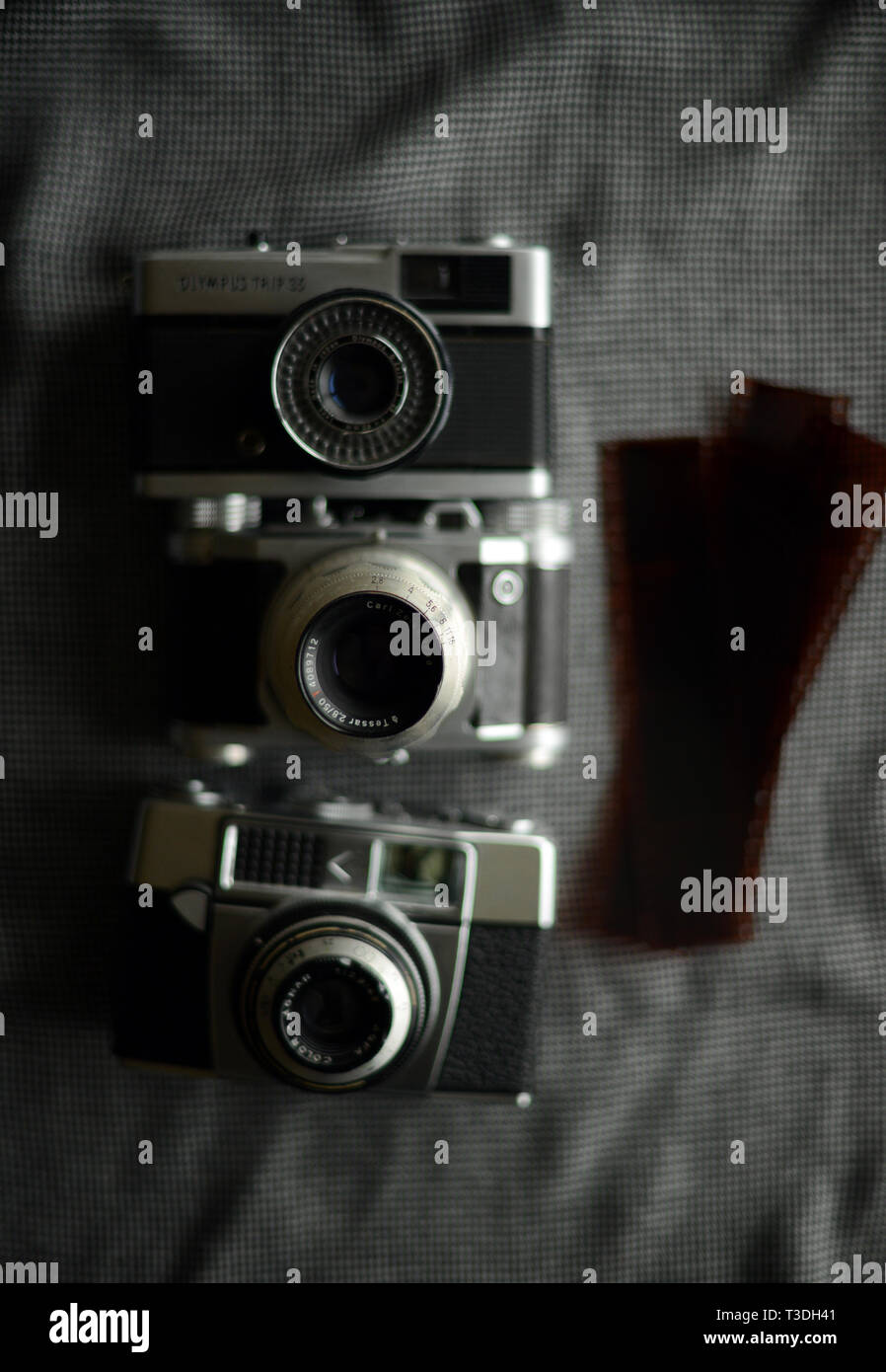 three antique vintage film cameras and film negatives Stock Photo