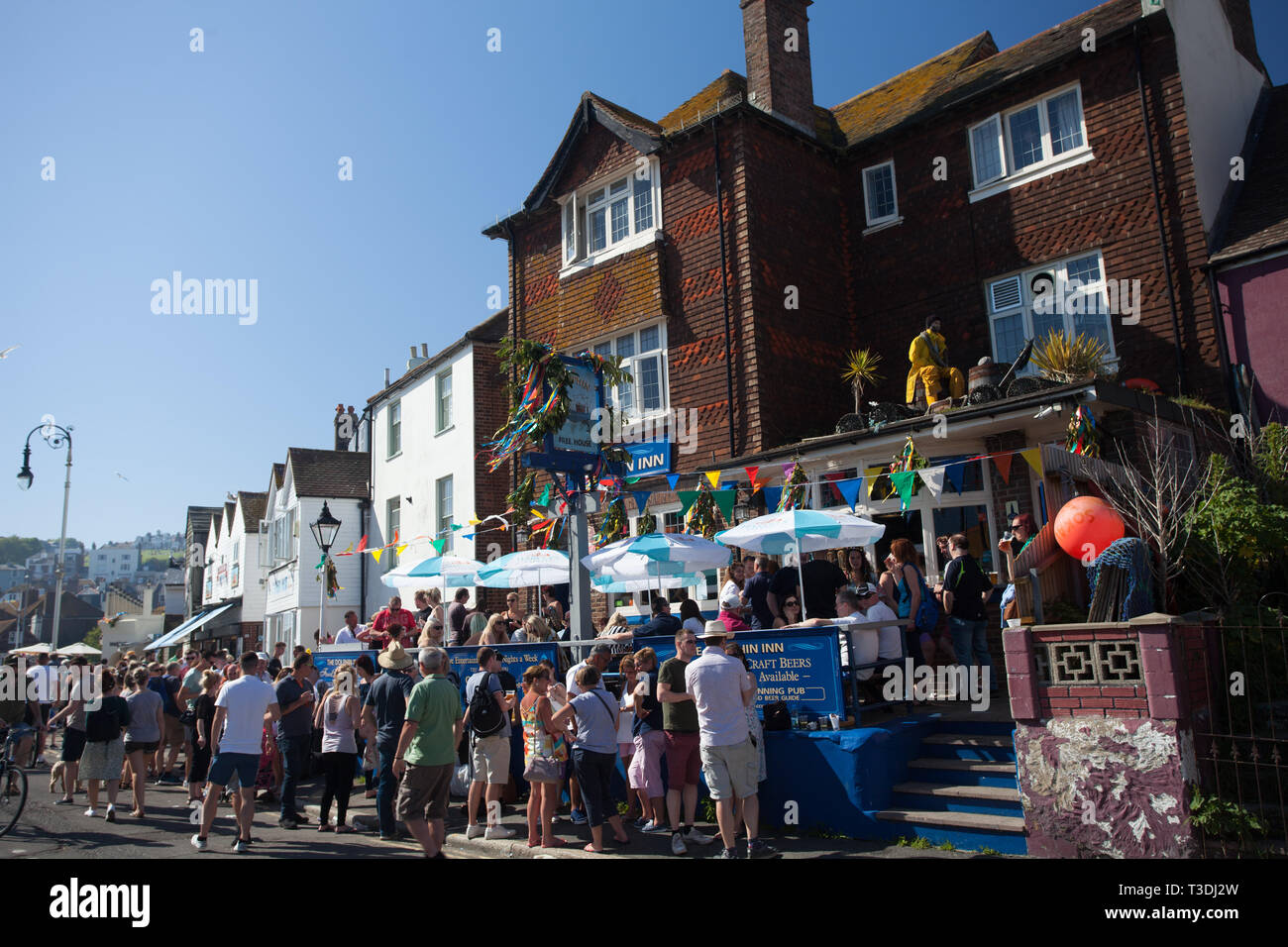 Revellers drinking outside the Dolphin Inn pub on a sunny day during Jack on the Green May Day Bank Holiday, Hastings, East Sussex, Uk Stock Photo