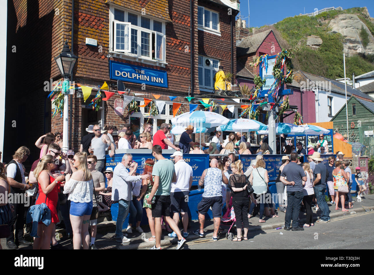 Revellers drinking outside the Dolphin Inn pub on a sunny day during Jack on the Green May Day Bank Holiday, Hastings, East Sussex, Uk Stock Photo