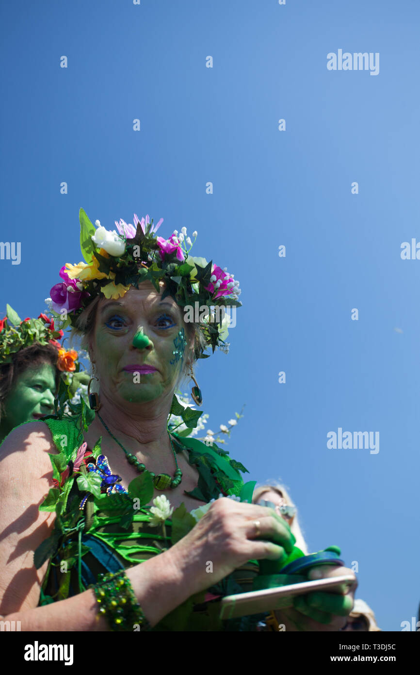 Funny look from a female participant dressed in green foliage at Jack in the Green procession, May Day Bank Holiday, West Hill, Hastings, UK Stock Photo
