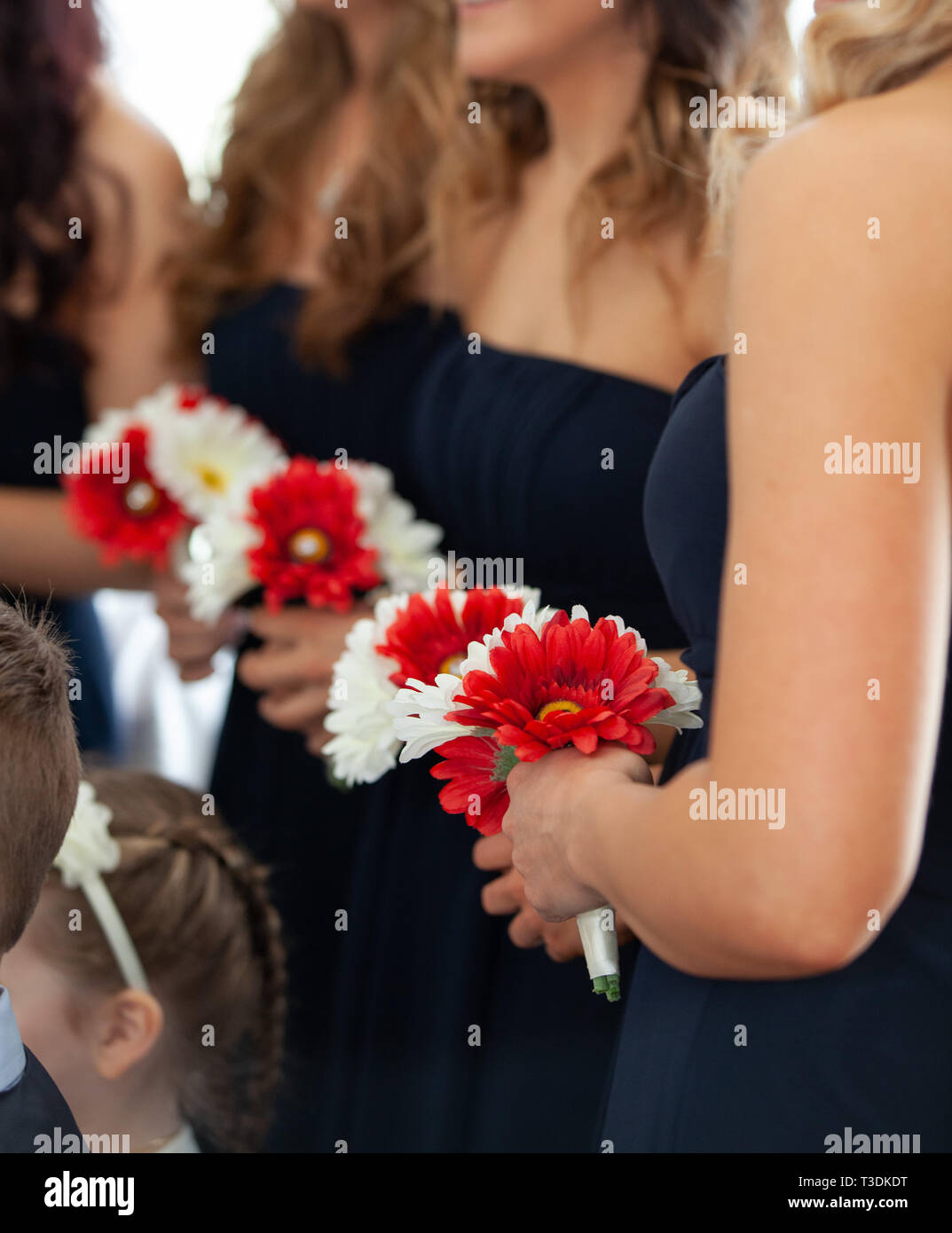 Bridesmaids at a wedding holding red and white flower bouquets Stock ...