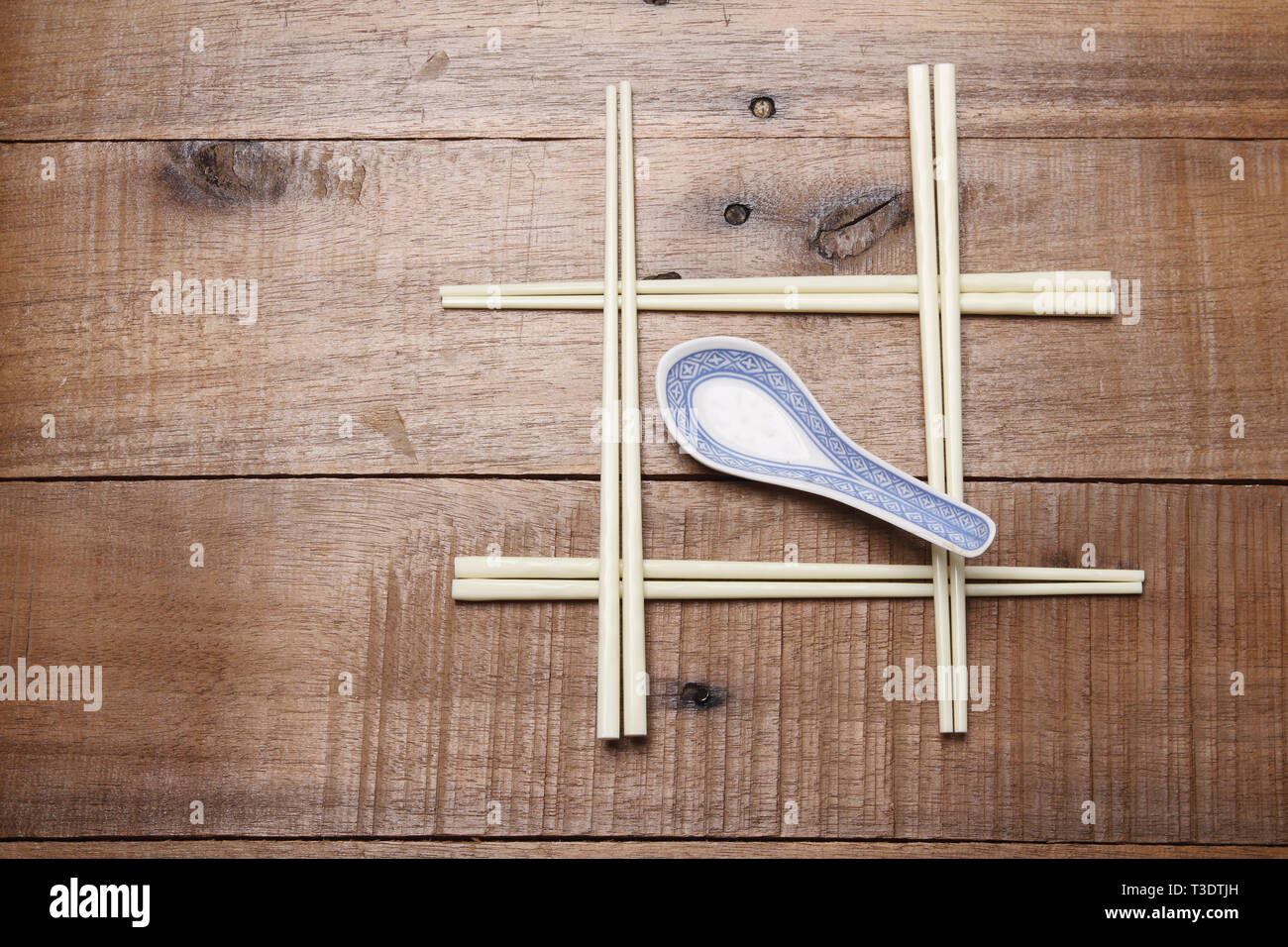 Chopsticks and Soup Spoon on Wooden Background Stock Photo