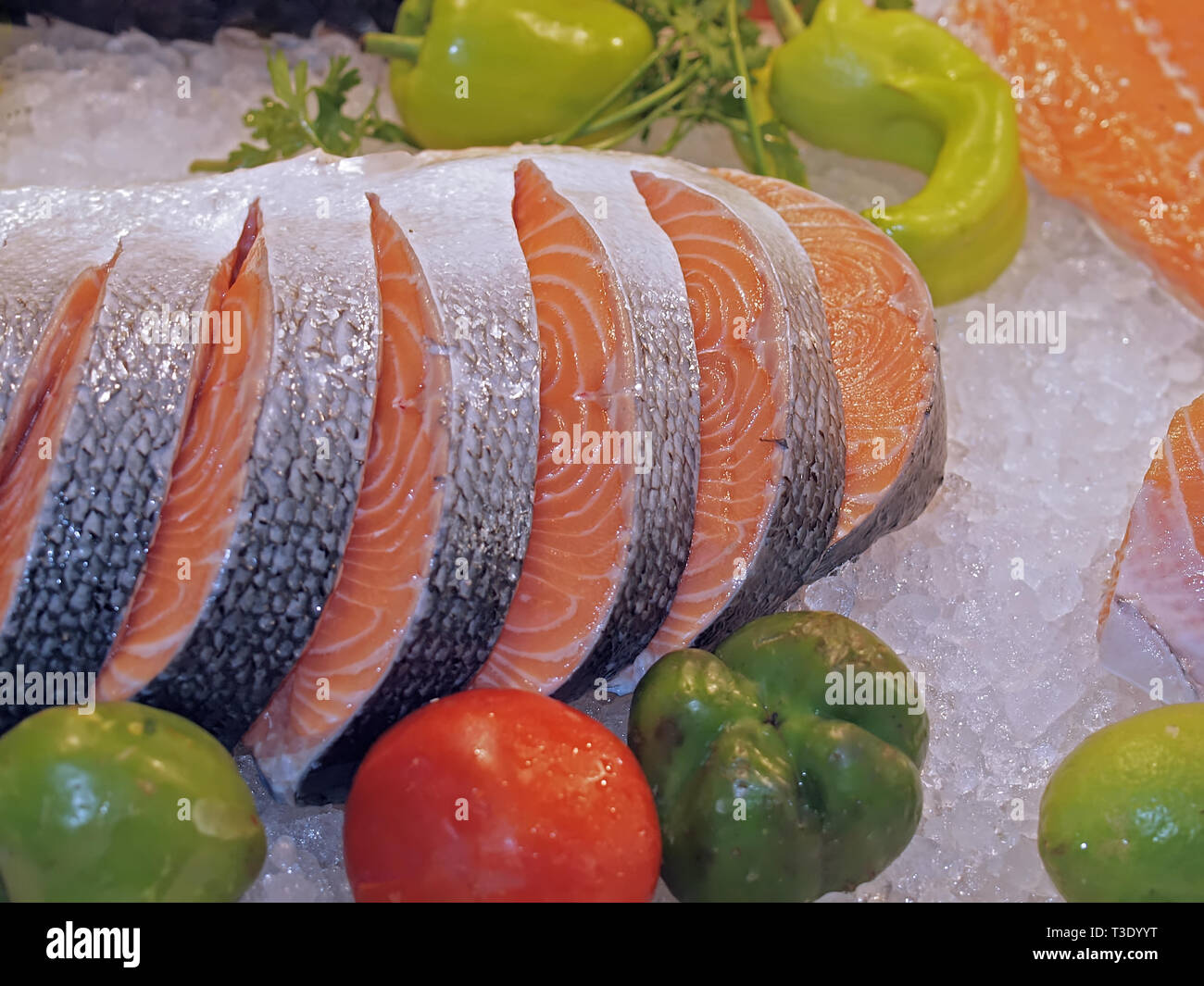 Raw salmon on ice at a fish market with vegetables Stock Photo - Alamy