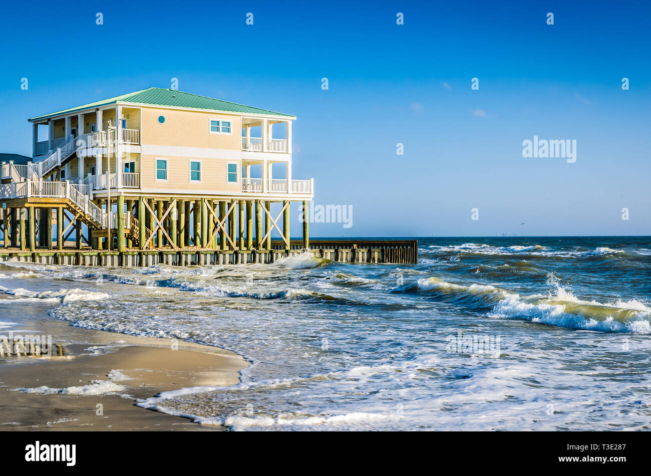 Waves crash alongside a beach house on Dauphin Island, Alabama Jan. 11, 2014. Stock Photo