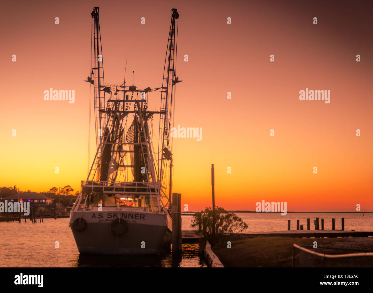 The sun sets on the A.S. Skinner shrimp boat, docked in Dauphin Island