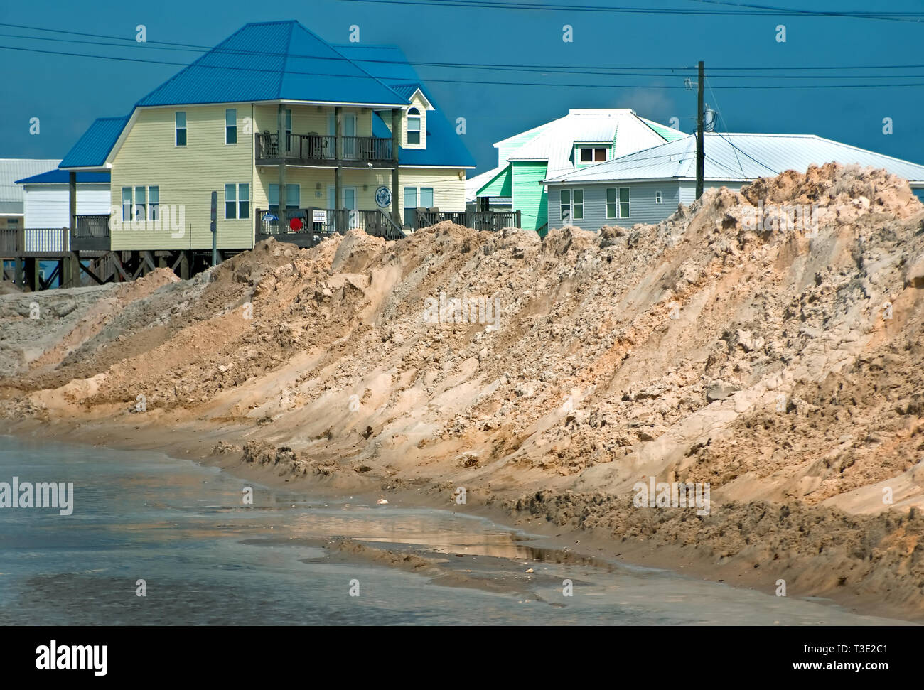 Beach homes are almost completely obscured by sand piles on the west end of Dauphin Island, Alabama, where efforts are underway to protect it from oil. Stock Photo