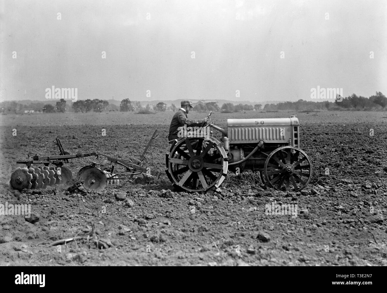 Farmer driving Ford Tractor in field ca. 1917 Stock Photo