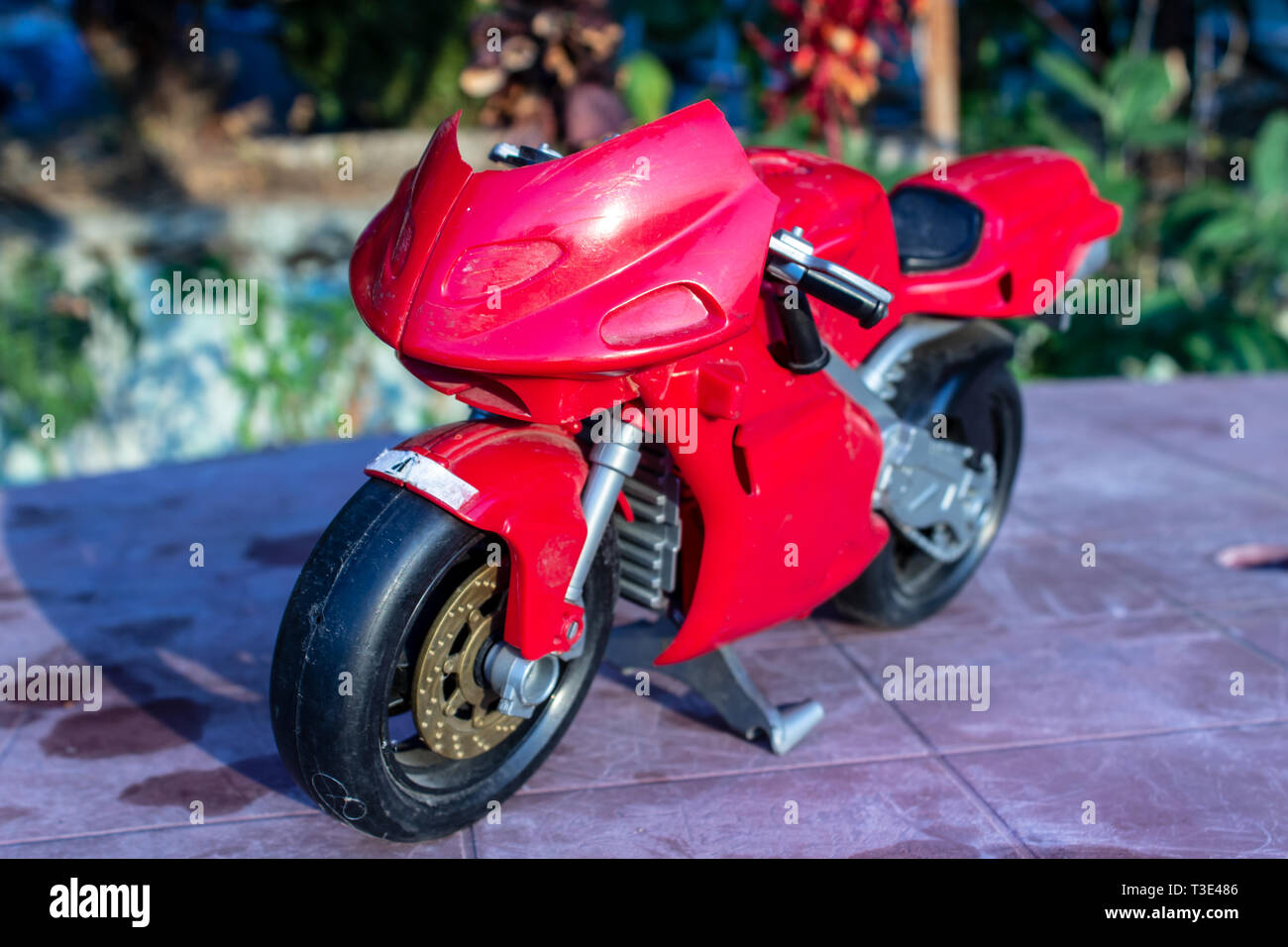 a isolated closeup red toy motorcycle with cold colors. photo has taken from a garden. Stock Photo