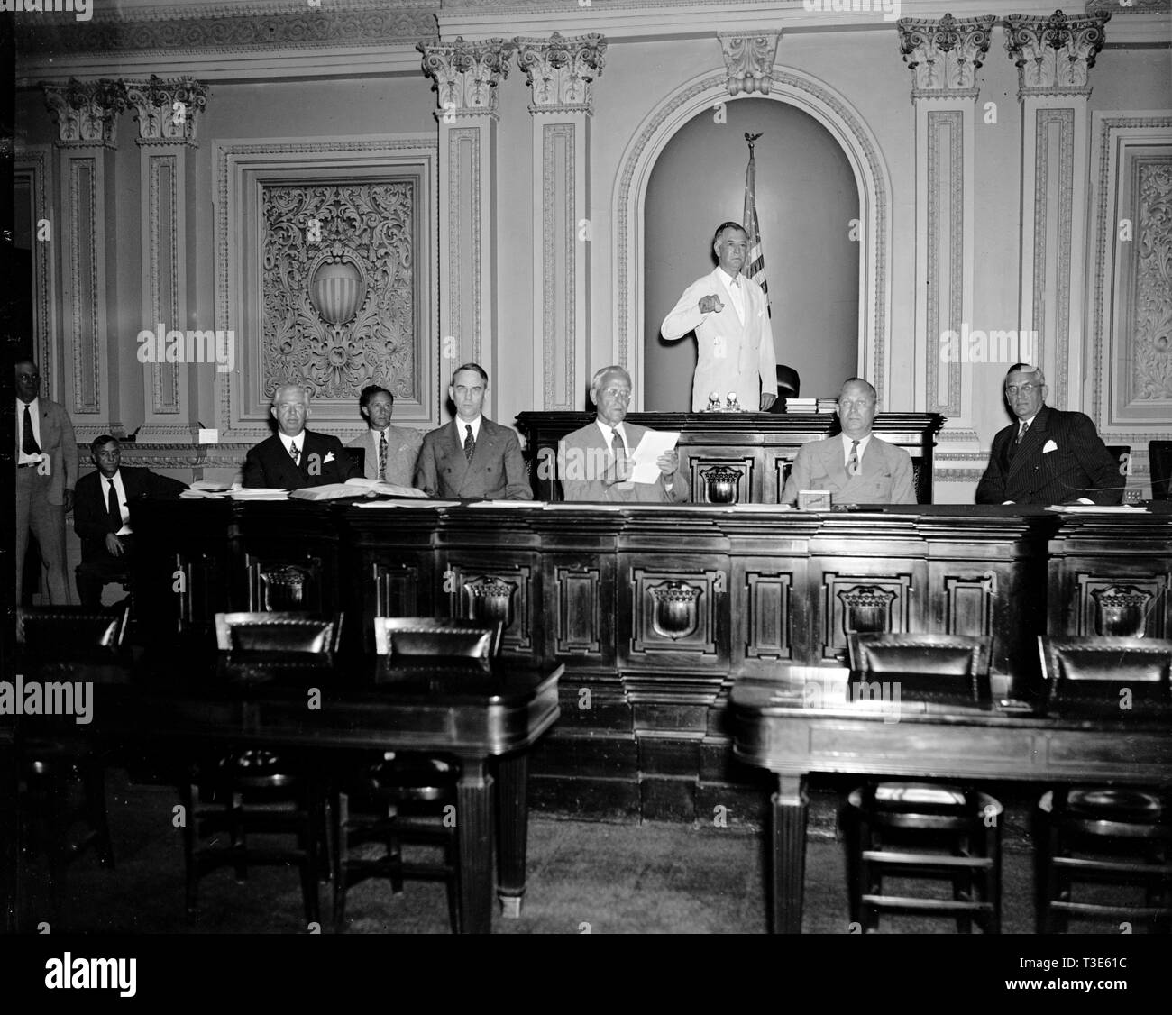 While Vice President Garner is vacationing in Texas during the next few weeks, Senator Key Pittman, President Pro Tem will preside over the Senate. Senator Pittman is shown with other officers of the Senate as the session opened this morning. Left to right: Chesley W. Jurney, Sergeant at Arms; Leslie L. Biffle, Secretary to the Majority; Charles L. Watkins, Parliamentarian and Journal Clerk; John C. Crockett, Cheif Clerk; Senator Key Pittman; Emery L. Frazier, Legislative Clerk; and Col. Edwin A. Halsey, Secretary. 6/14/37 Stock Photo