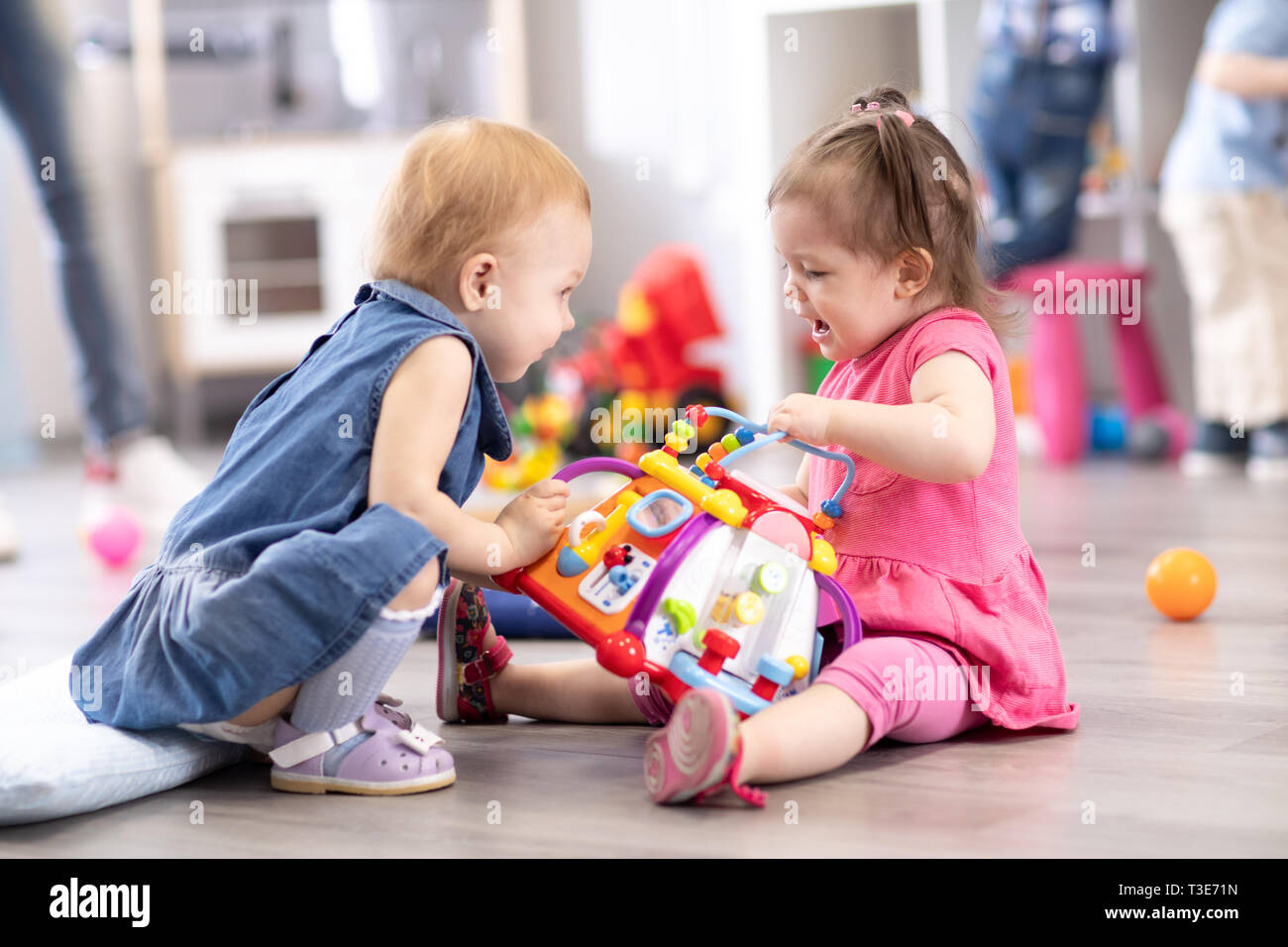 Conflict on the playground. Two kids fighting over a toy in kindergarten or nursery Stock Photo