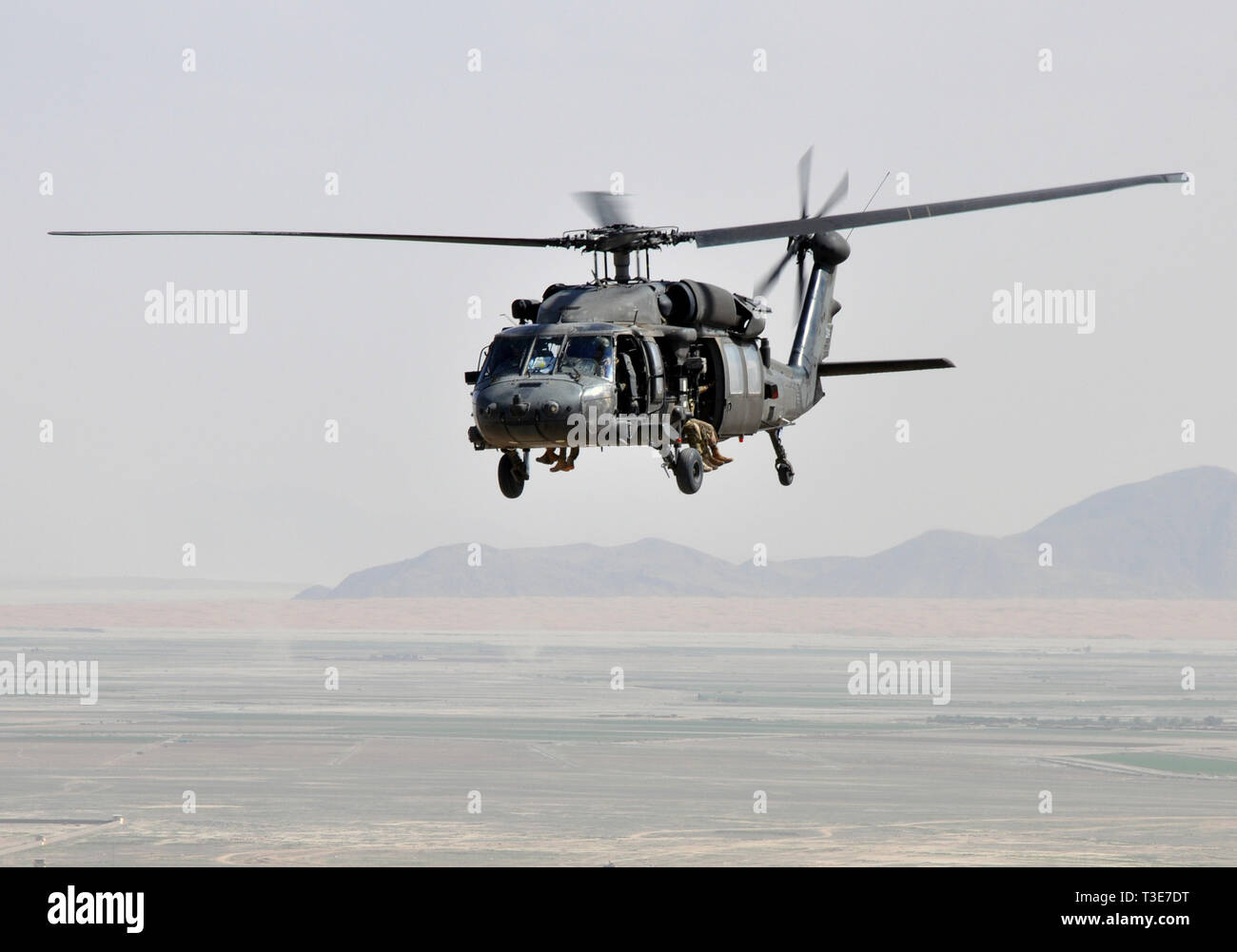 Army National Guardsmen and Air Force pararescuemen from the 64th Expeditionary Rescue Squadron fly in a UH-60 Blackhawk helicopter over Kandahar, Afghanistan, during joint training April 5, 2019. The rescue Airmen and Soldiers work and train together regularly to be prepared to save lives across the region. (U.S. Air Force photo by Capt. Anna-Marie Wyant) Stock Photo