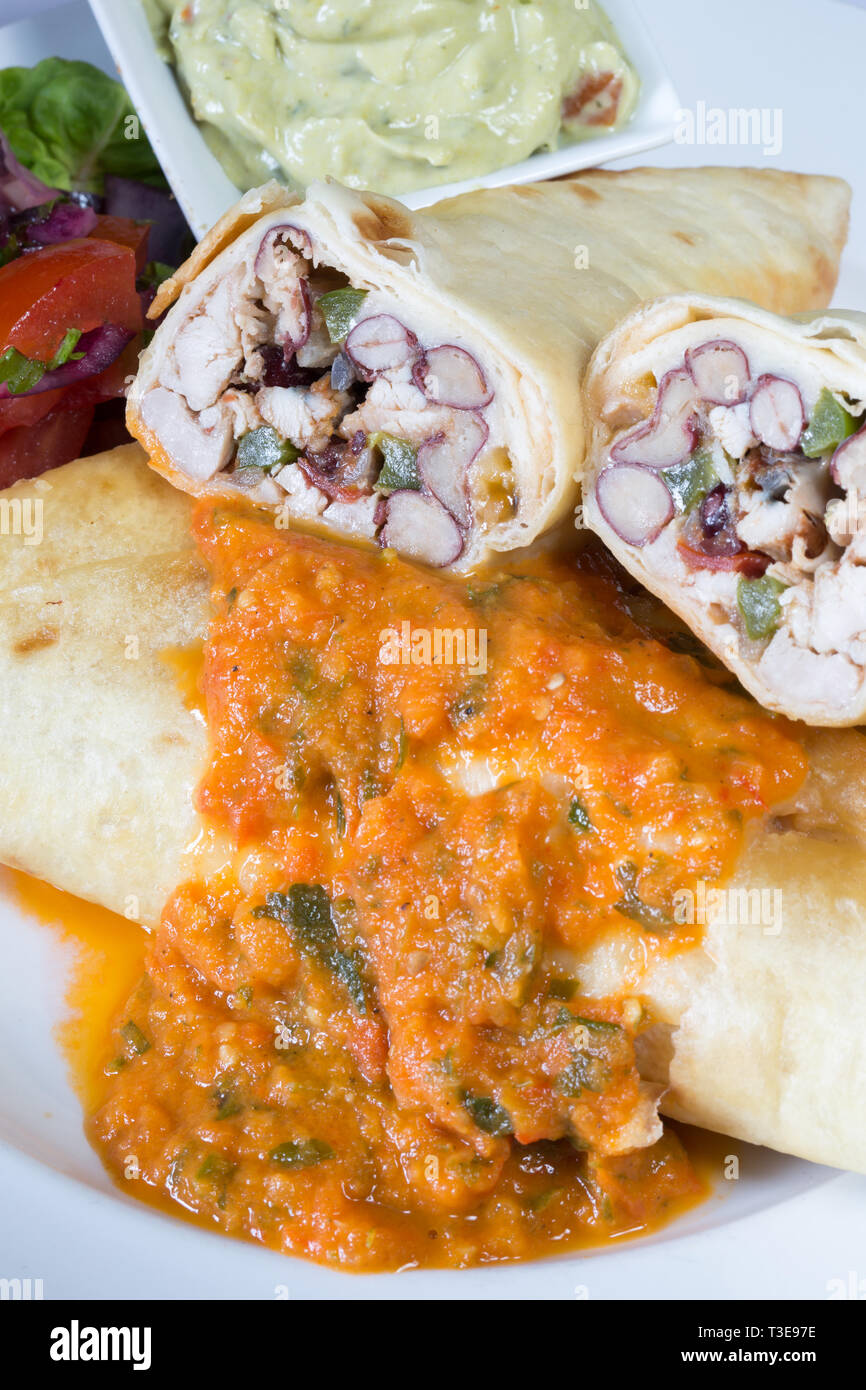 Mexican Chicken and re-fried bean Chimichanga with tomato salsa and hot chili sauce Stock Photo