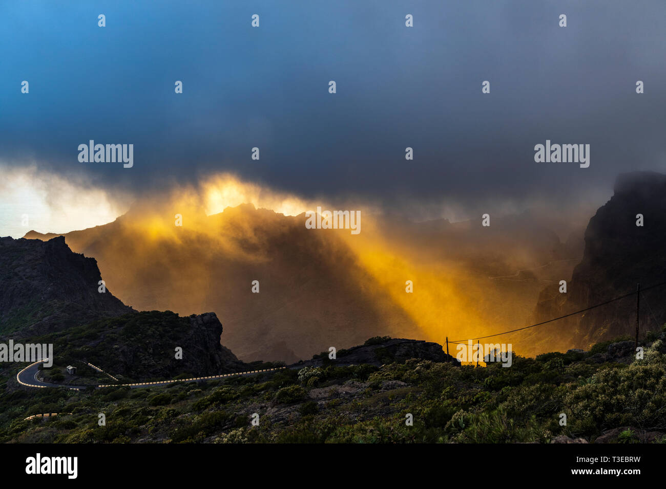 Rainclouds blowing across the sky with rays of light late in the day just before sunset over the Teno Masif as seen from the Degollada del Cherfe, Mas Stock Photo