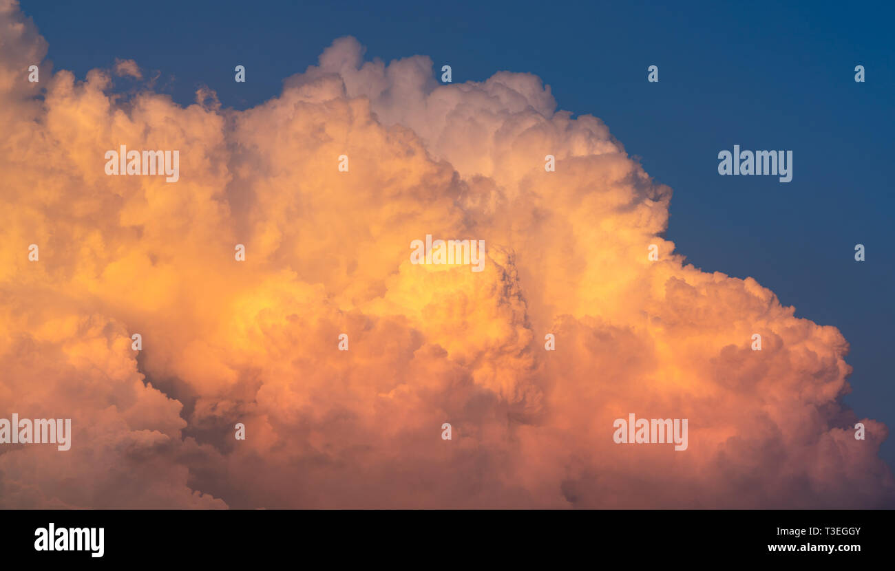 Blue sky and white fluffy clouds on sunset sky. White cumulus clouds. Dramatic sky and clouds abstract background. Warm weather background. Art pictur Stock Photo