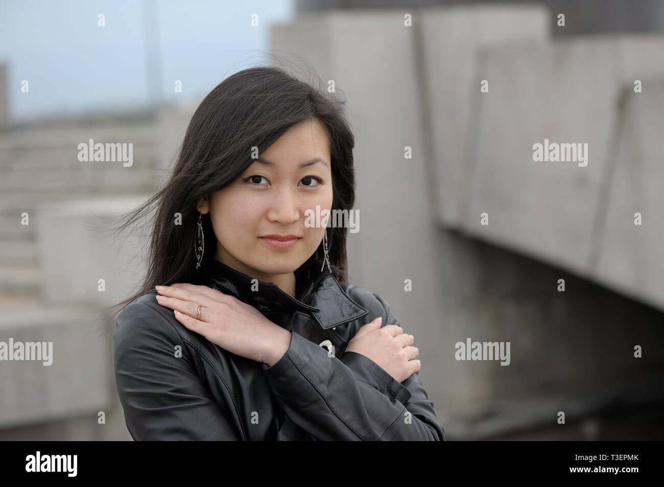 Asian girl in black jacket at city Stock Photo