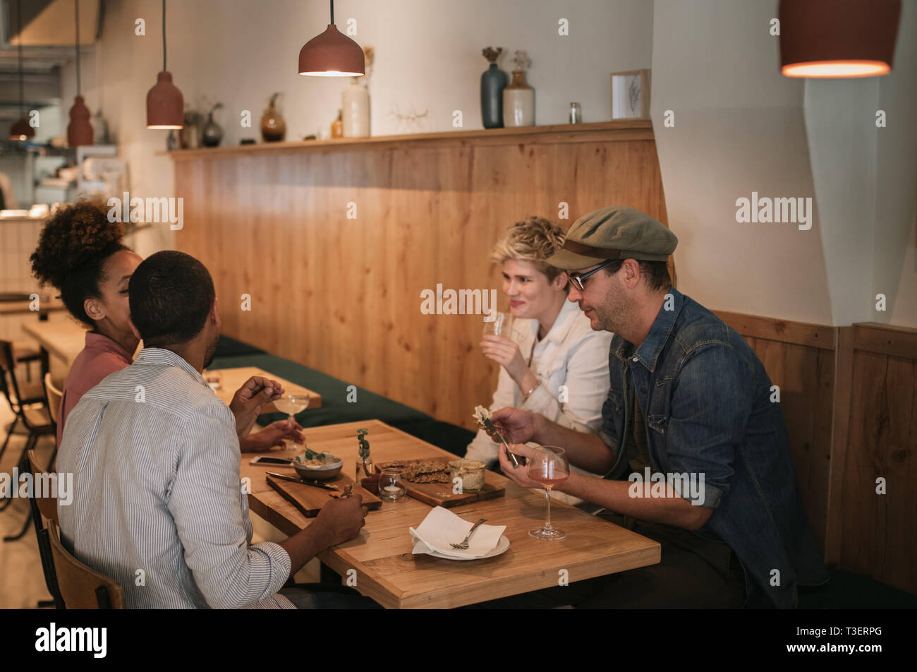 Content friends sharing food together in a bar Stock Photo