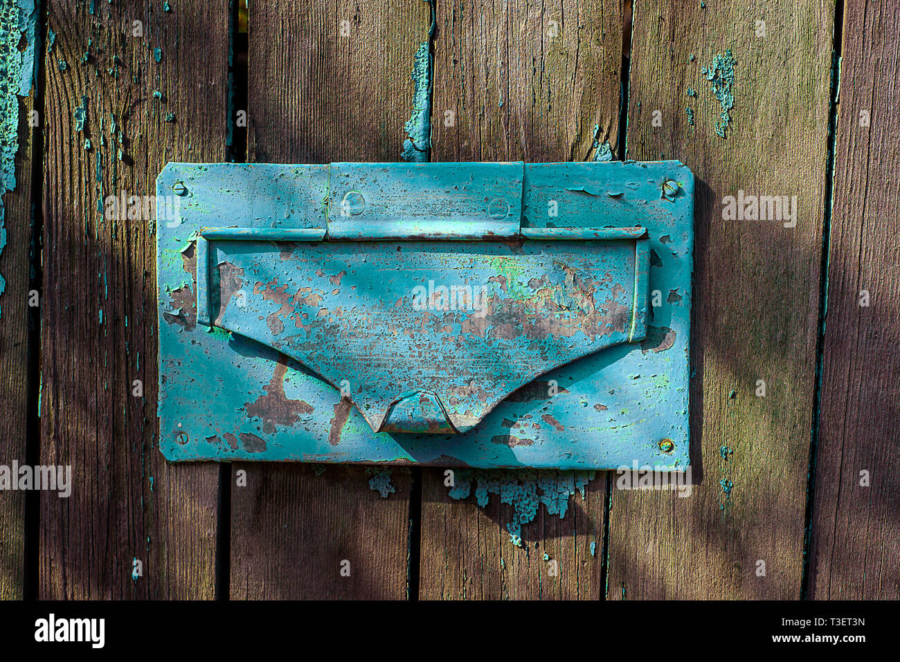 Mail hole with painted steel and cap on old wooden fence Stock Photo