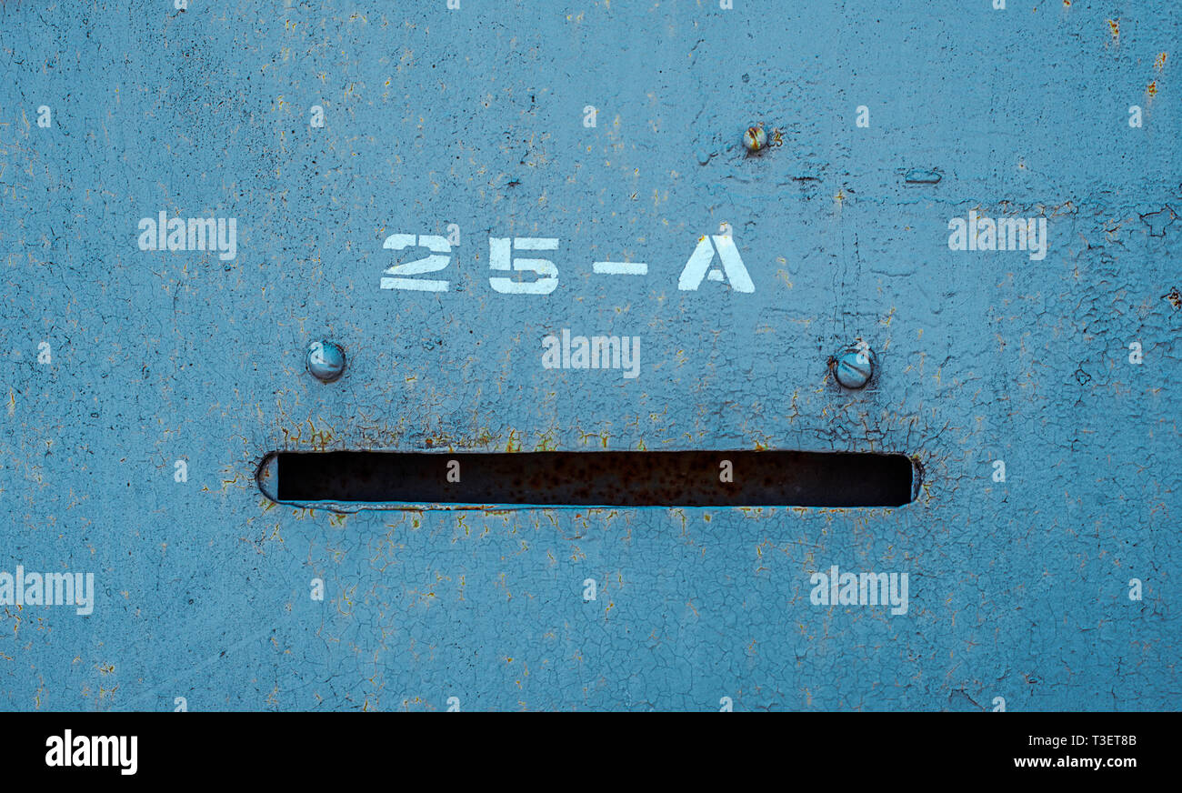 Old blue painted metal door with number twenty five and A and mail hole. Horizontal texture of cracked paint on rusty steel Stock Photo