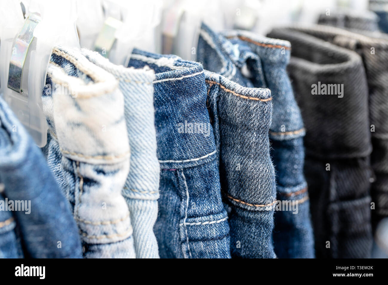 Many blue jeans on hangers for sale in local street market in Thailand, close up Stock Photo Alamy