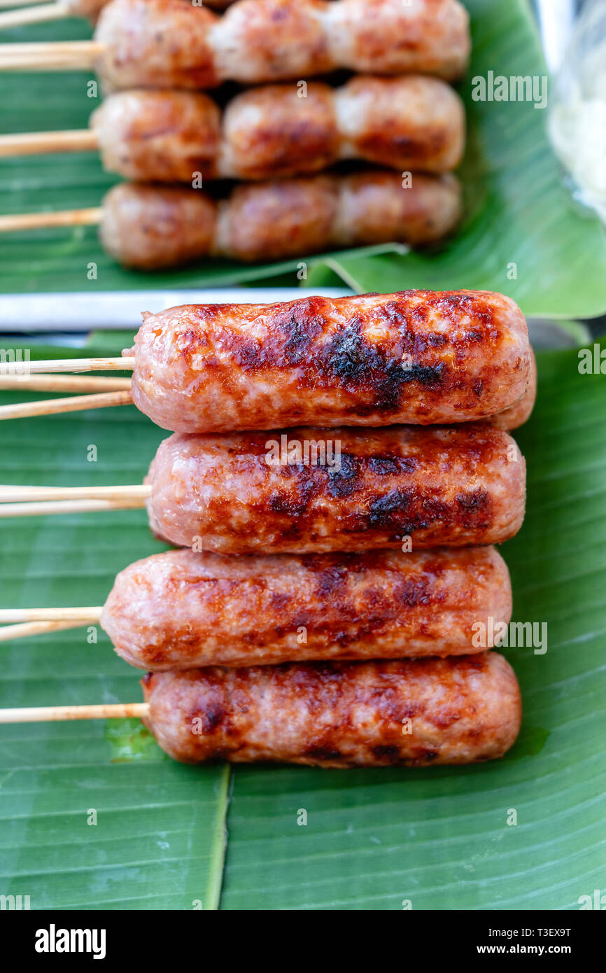 Grilled Thai sausage at street food market in Thailand, close up. Traditional Thai sausage with