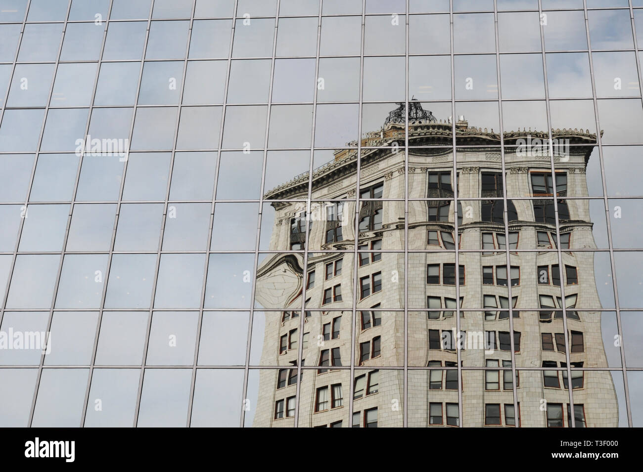 Reflected in the PNC Bank Building, the historic McKay Tower in downtown Grand Rapids, Michigan was the city's tallest building from 1927 until 1983. Stock Photo