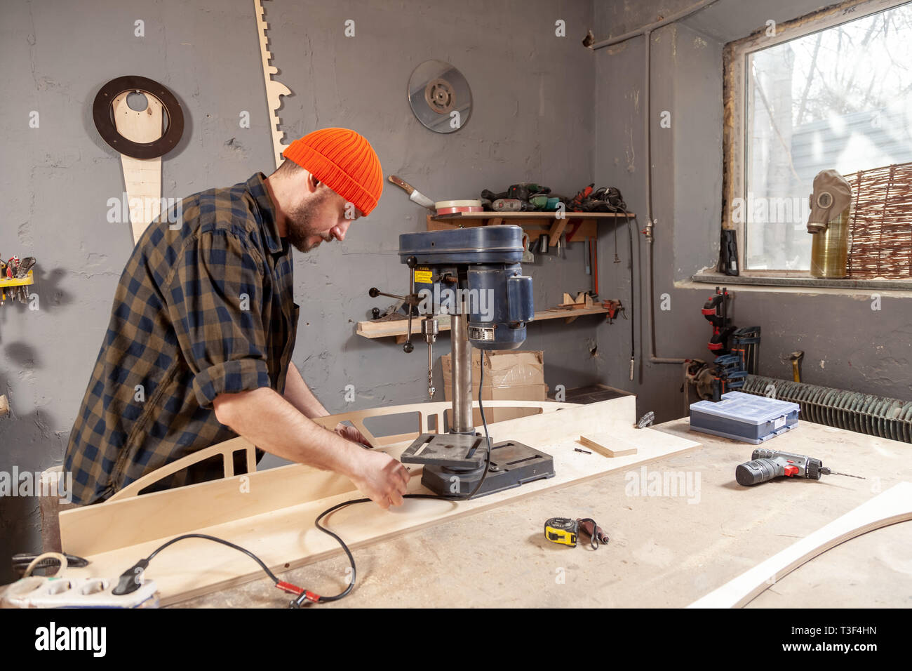 Close up of carpenter in work clothes carving a wooden on an drill