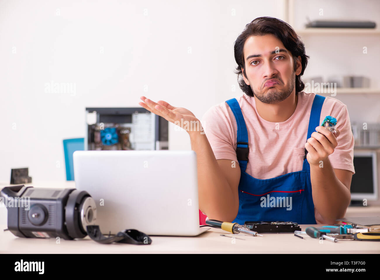 Young male contractor repairing computer Stock Photo