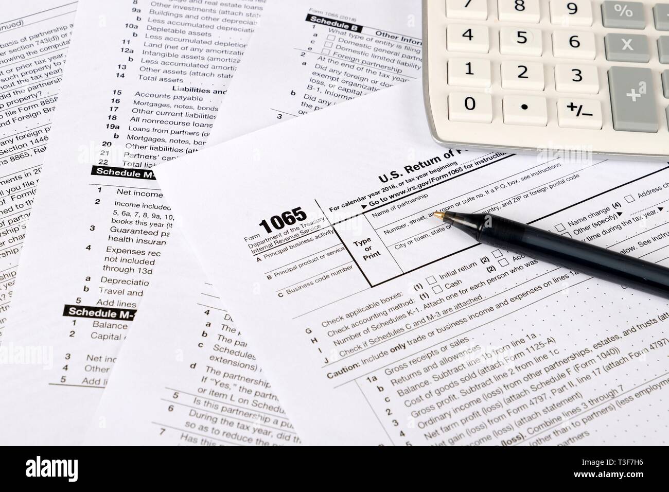 1065 tax form lies near hundred dollar bil and calculator  on a Table. US Return for parentship income Stock Photo