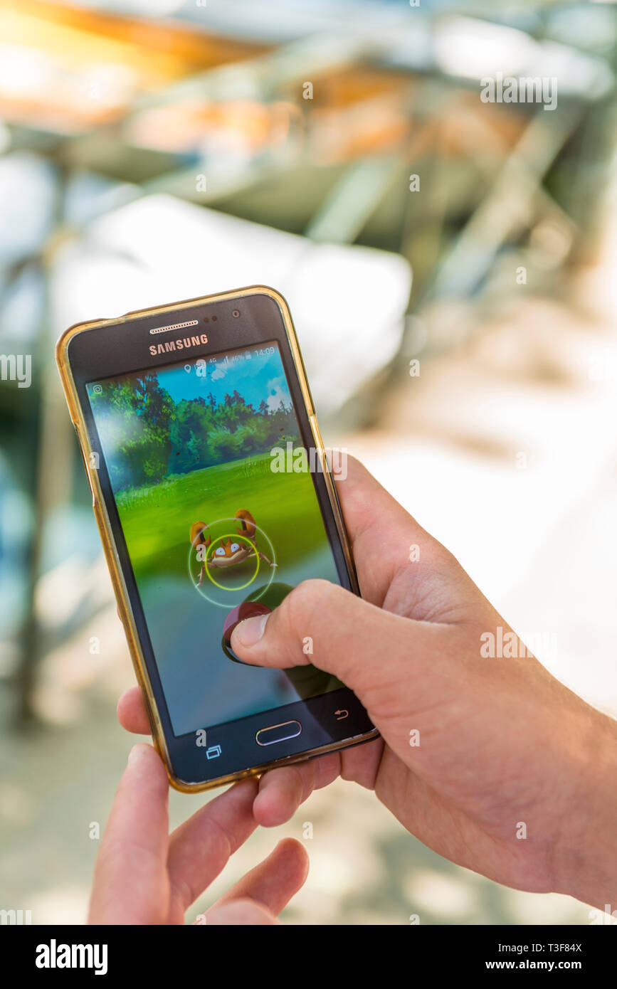 Pokemon Go, augmented reality game : young man looking for Pokemon characters Stock Photo