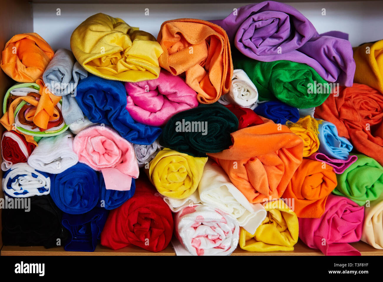 Pile of vibrant colorful rolled up fleece textile. Fabric for toys ...