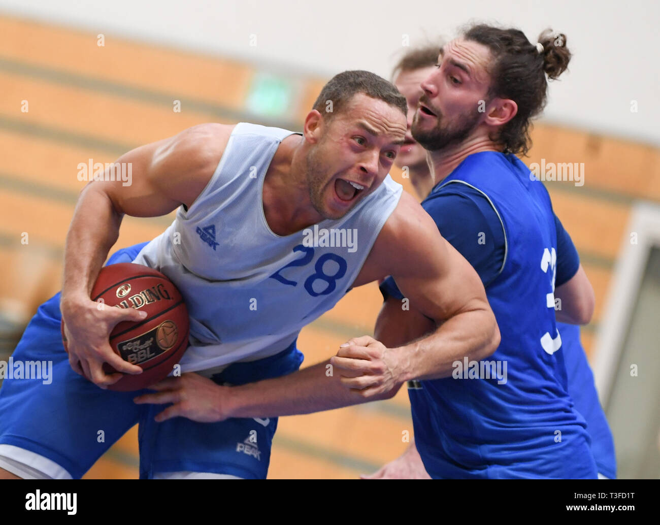 09 April 2019, Hessen, Frankfurt/Main: Andrej Mangold (l), "TV Bachelor",  is attacked by Marco Völler during the training of the basketball team  Fraport Skyliners. Mangold continues his professional career in Frankfurt.  Photo: