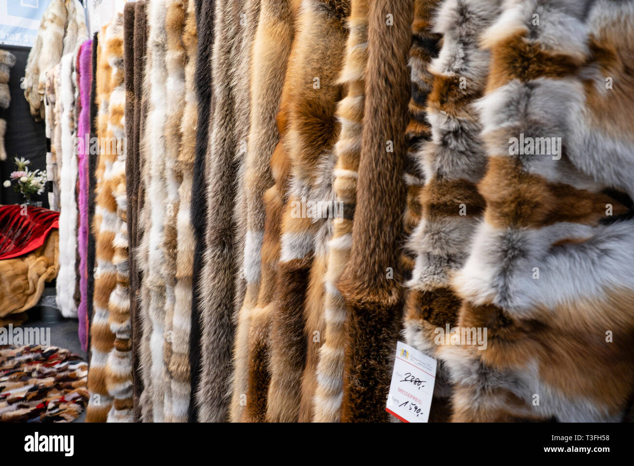 05 April 2019, Schleswig-Holstein, Neumünster: Real fur blankets hanging  from a sales stand at the 
