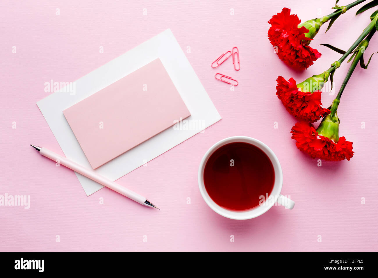 Red Pink Object Red-pink objects. Cup of tea, carnation flowers Notepad for text on ...
