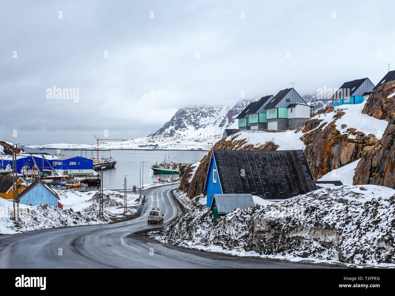 Acrtic road to the docks and port between the rocks with Inuit houses, Sisimiut, Greenland Stock Photo
