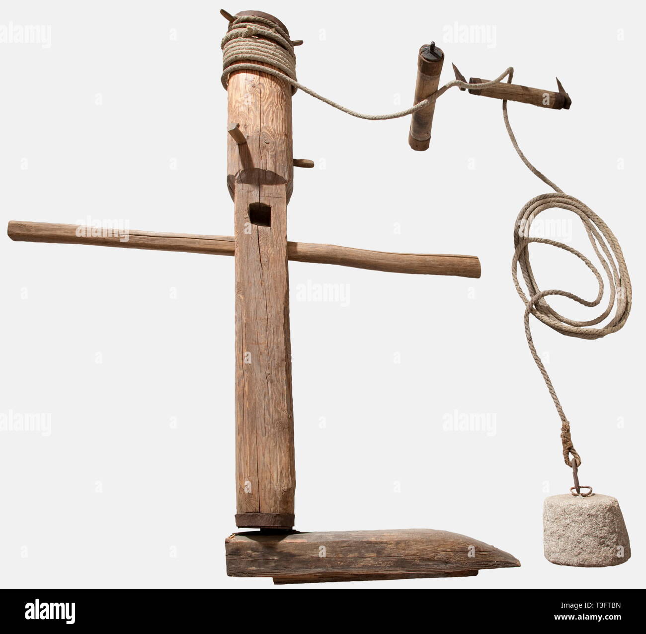 A large windlass for suspension torture, Southern Germany/Austria, 17th/18th century Softwood with iron bands. Vertical windlass with two pulleys. Horizontal base made of a rectangular beam with an inset iron pedestal. Vertical windlass, the lower half quadratic with large rectangular openings for the turning bars. The upper half is round set with crank pins for the heavy hemp rope. Two pulleys with forged iron bearings. Also a slightly conical stone weight of granite with an iron suspension ring. Height 210 cm. The suspension device is one of th, Additional-Rights-Clearance-Info-Not-Available Stock Photo