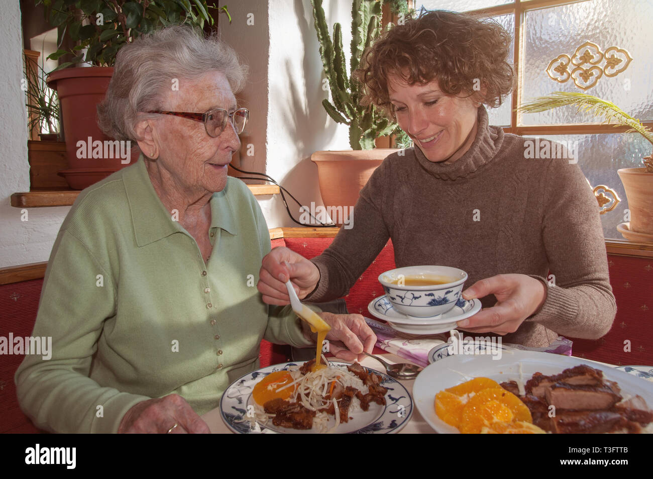 Senior woman and daughter eating in restaurant Stock Photo