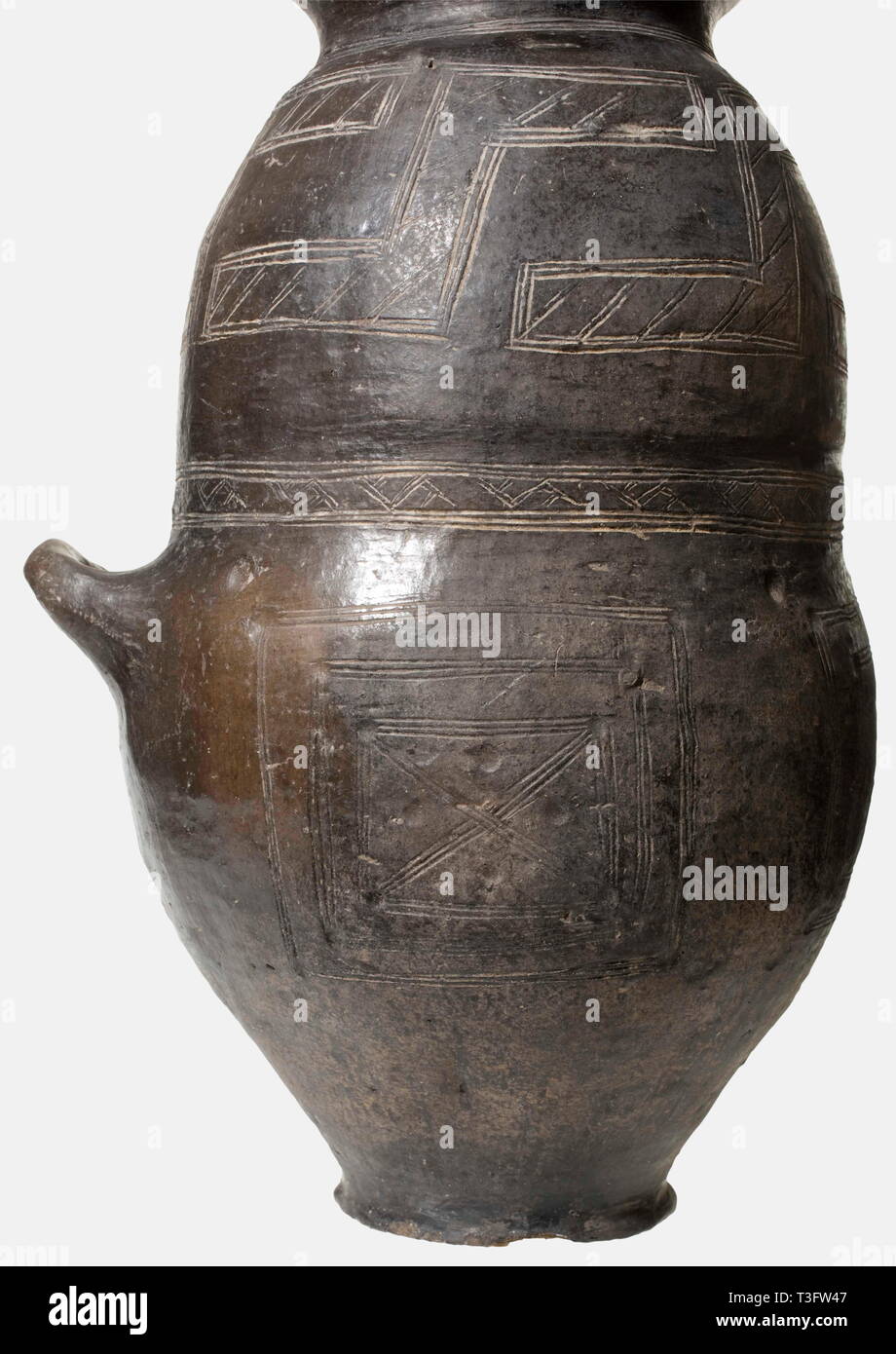 A cinerary urn with a helmet lid, Villanova, 9th/8th century B.C. Dark brown to black clay. One-handle urn with a constricted top and a strongly flaring rim. The surfaces have scratched and whitened geometric decoration: rectangular fields, swastikas, bands with hatched Z patterns, and bands of crosses. The helmet lid has a high sculpted crest, and decorative crosshatched bands along the lower edge. Height of the urn 39 cm. Height of the helmet 25 cm. Very good condition. Small improvements to the rim of the vessel, the helmet point, and the base, Additional-Rights-Clearance-Info-Not-Available Stock Photo