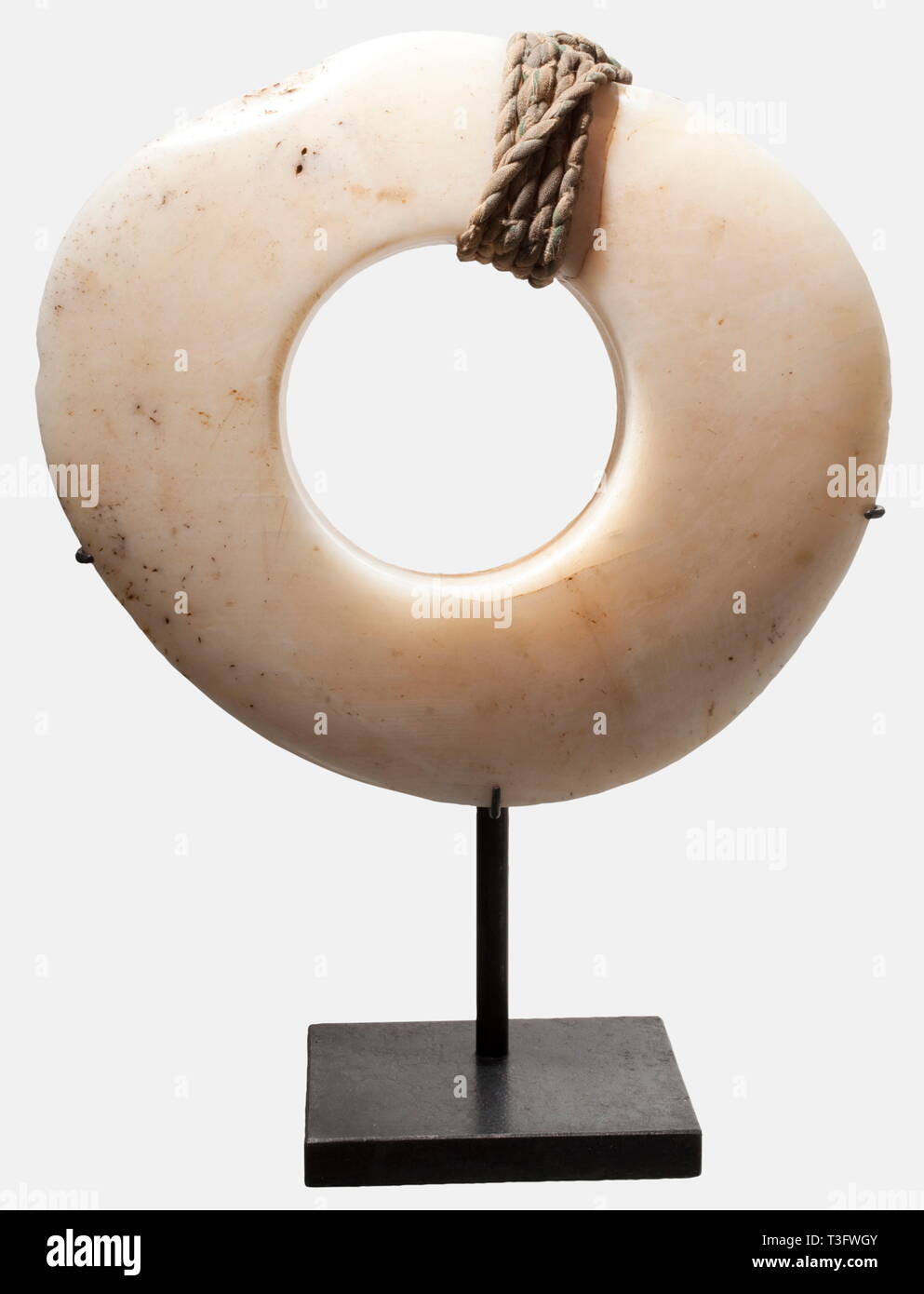 A shell money ring of the Abelam, Papua New Guinea Polished, massive ring cut from a seashell. The original grain of the shell is still recognisable. On the upper part wrapped with greenish textile. 20 cm in diameter, weight 1120 g. Shell money rings are still an important means of payment for various luxury goods such as feathers of the bird of paradise or tobacco, or for the courtship. Large money rings have been family-owned for generations and served, so to speak, as 'assets of the last resort'. historic, historical, Indonesian archipelago, I, Additional-Rights-Clearance-Info-Not-Available Stock Photo