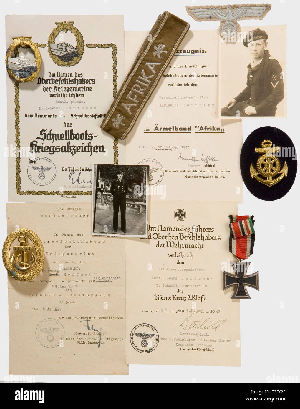 Decorations and documents, for a machinist's mate in the 3rd E-Boat Flotilla 1st model E-Boat War Badge, patinaed non-ferrous metal with a fire-gilt wreath and silver-plated ship. The raised edges polished. Made by 'Schwerin Berlin 68'. Waisted transverse pin. Fastening hook. Award certificate with the depiction of a ship with Ship's Commander Rudolf Petersen's ink signature. Iron Cross 2nd Class with ribbon, and the citation for 9 January 1942 with the ink signature of Rear Admiral, and Commander of the German Navy in Italy, Weichold. 'Afrika' sleeve band (tailor made, cam, Editorial-Use-Only Stock Photo