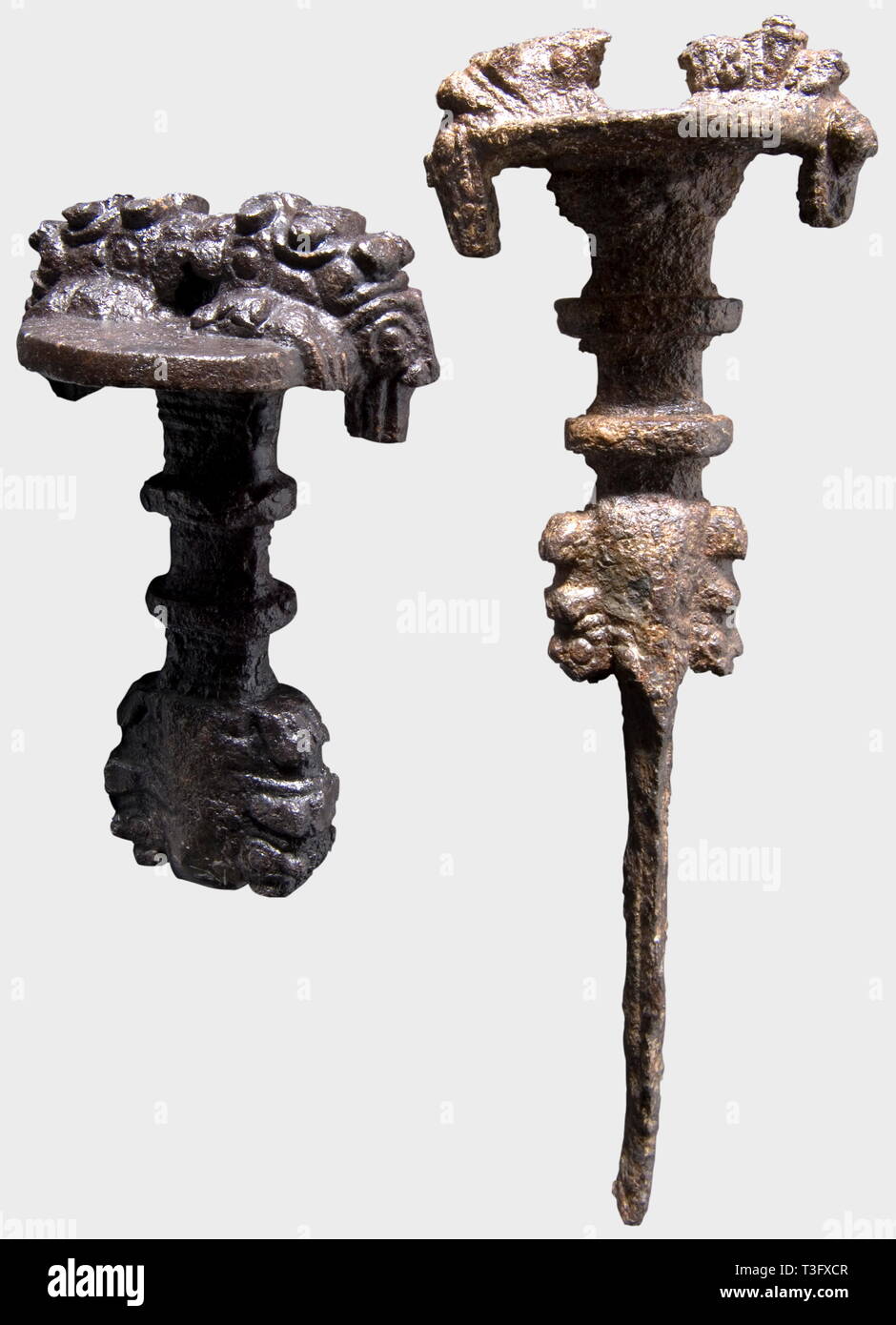 Two fragments of ancient near eastern iron mask-swords, 10th to 8th centuries B.C. Flat profiled iron hilt chiselled with two reclining lions, on the pommel flat two strongly stylised lion masks behind bearded human heads. Length 11.5 cm. Professionally conserved, in excellent state and with a fine pyre patina. Also another fragment with part of the blade conserved. Length 24 cm. Provenance: Axel Guttmann collection, Hermann Historica, auction 44, 15th May 2003, lots 6 and 7. historic, historical, ancient world, ancient world, ancient times, obje, Additional-Rights-Clearance-Info-Not-Available Stock Photo